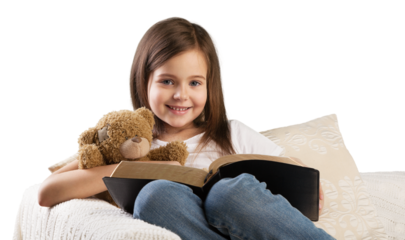 Cute child girl reading a book in bed before going to sleep