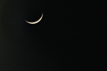 Obraz na płótnie Canvas A crescent moon with black sky in background