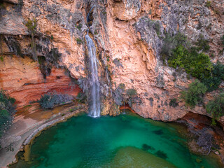 Waterfall with small lake and turquoise water from above