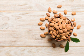 Fresh healthy Almond in bowl on colored table background. Top view