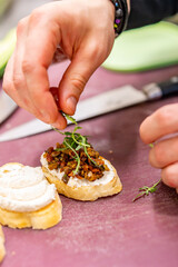man chef hand cooking Bruschetta with tapenade and cream cheese on restaurant kitchen