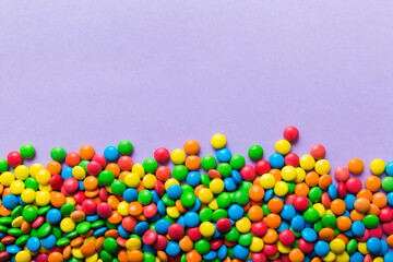 Mixed collection of colorful candy, on colored background. Flat lay, top view. frame of colorful chocolate coated candy