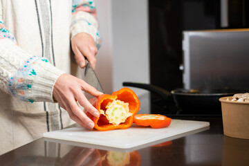 Obraz na płótnie Canvas Girl cooking. Girl cutting red pepper