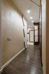 Long corridor with interior doors in an ordinary small apartment