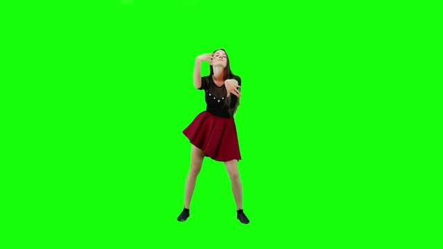 A Young Woman In Red Dress Dancing On A Green Screen Background