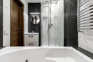 Bathroom with shower and large Jacuzzi bathtub with contrasting white and black walls