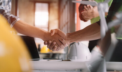 Obraz na płótnie Canvas architects and engineers shake hands while working for teamwork and cooperation after completing an agreement in an office facility, successful cooperation concept.