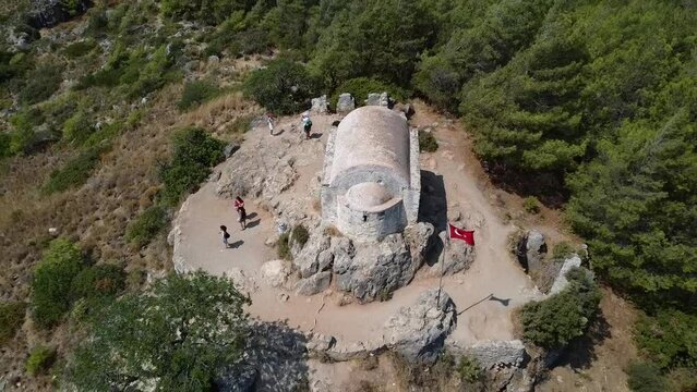 Aerial footage of abandoned town and chapel on the hill, top view of kayakoy ruins odl stone houses. 360 degree shooting with drone