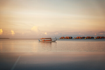 Naklejka premium boat on the sea at sunset