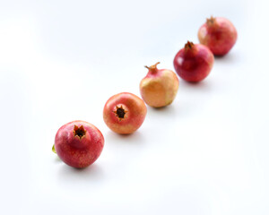 Pomegranates isolated on white background with shadows. Set of whole ripe fruit, red, pinkish, and yellow with clear details and smooth blur. Fresh healthy food. Harvest from a garden. 