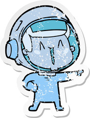 distressed sticker of a happy cartoon astronaut pointing