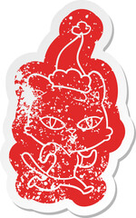 cartoon distressed sticker of a cat out for a run wearing santa hat