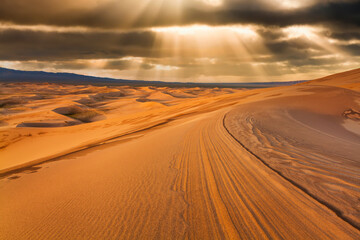 Fototapeta na wymiar Sunset over the sand dunes in the desert. Arid landscape of the Sahara desert.