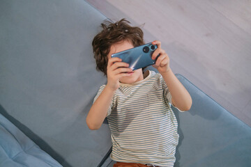 portrays a child engrossed in his phone, sparking a debate on the impact of technology on young...