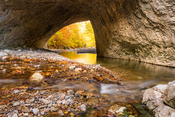 Natural stone bridge over a creek in autumn