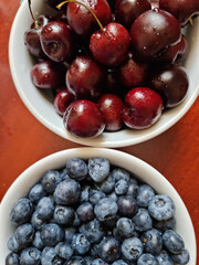 cherries and blueberries in bowls on the table. High quality photo