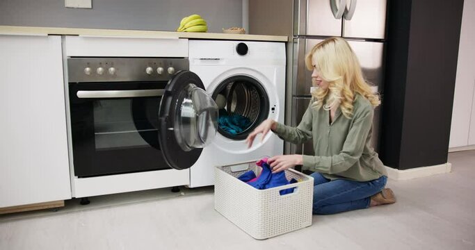 Woman Loading Dirty Clothes In Washing Machine For Washing