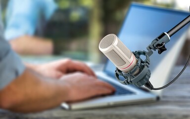 A man streaming podcast using classic microphone and laptop