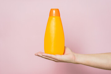 Shampoo bottle in hand. Spa beauty treatment and skin, body and hair care concept. Bath accessories