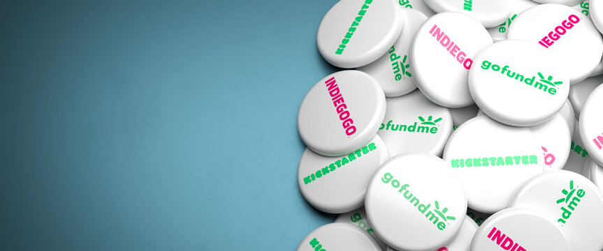 Logos of the main crowdfunding platforms Kickstarter, Indiegogo, GoFundMe on a heap on a table. Copy space. Web banner format.