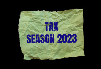 Tax Season 2023 words written on paper. Isolated on a black background. Business concept photo.