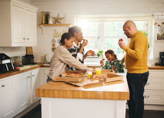 Family with boy with Down syndrome enjoying takeaway pizza for dinner