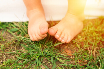Children's feet on the ground, sunset picnic