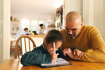 Obraz premium Multiracial father and son with Down syndrome using digital tablet