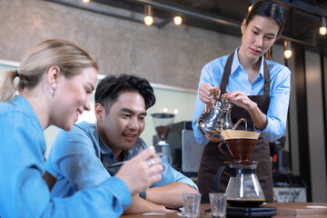 Male and female students learn to brew coffee in barista school.