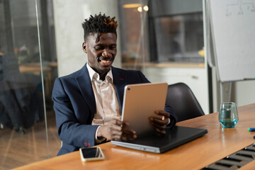 Portrait of successful businessman in office. Handsome businessman using digital tablet..