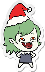 sticker cartoon of a laughing vampire girl wearing santa hat