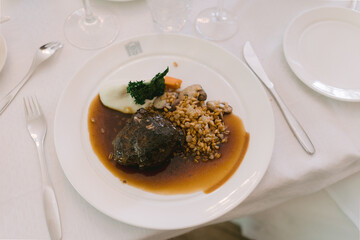 Beef steak with buckwheat porridge in a white plate