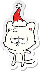 bored distressed sticker cartoon of a cat wearing santa hat