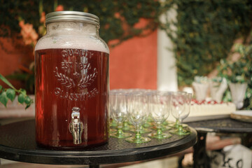 A bottle of punch on a table in a restaurant. Close-up