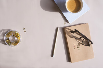 aesthetic minimalist workspace. Home office, blog, social media concept. Note book, coffee and glasses in soft pastele colors