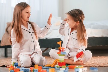 Giving high five. Two little girls are playing and having fun together in domestic room