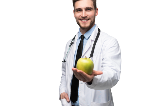 Portrait of handsome doctor in white coat looking at camera and smiling while holding an apple, isolated 
