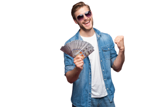 Portrait of joyful man in jeans shirt holding bunch of money banknotes while standing and celebrating isolated over transparent background