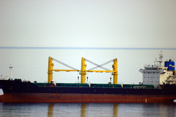 Fototapeta na wymiar Black-brown ship stands in a clear calm sea close-up