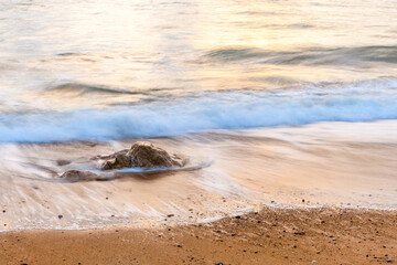 Wave crashing on a sandy beach of the Atlantic Ocean.