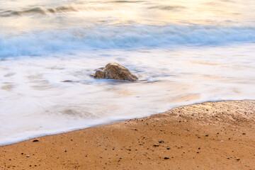 Wave crashing on a sandy beach of the Atlantic Ocean.