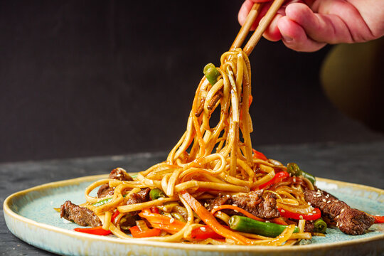 fried wok beef noodles on a black rustic background