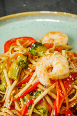 fried wok shrimp noodles on a black rustic background