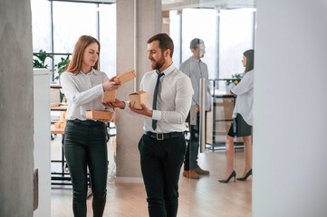 Walking together. Man and woman are with eco boxes that is with food is in the office