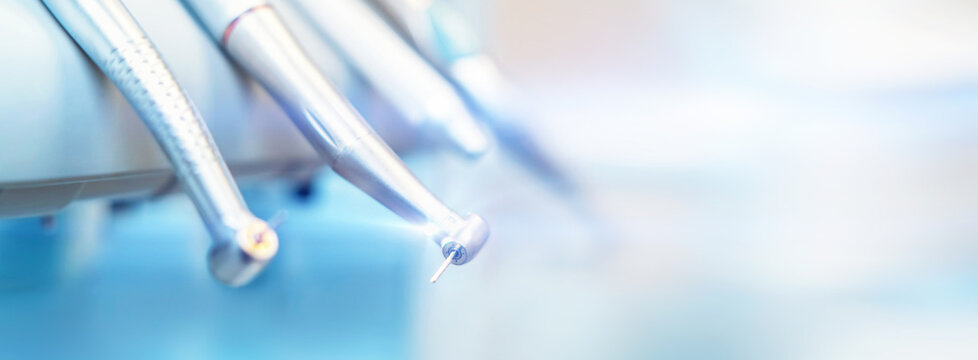 Closeup photo of dental handpieces and equipment on dental chair with blured background.