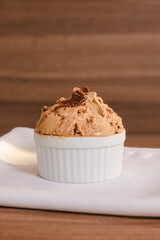 Light chocolate ice cream with ground chocolate cookies on a wooden table.