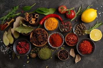 Set of spices and herbs. Indian food. Pepper, salt, paprika, basil, turmeric. On a black wooden board. View from above. Free copy space.