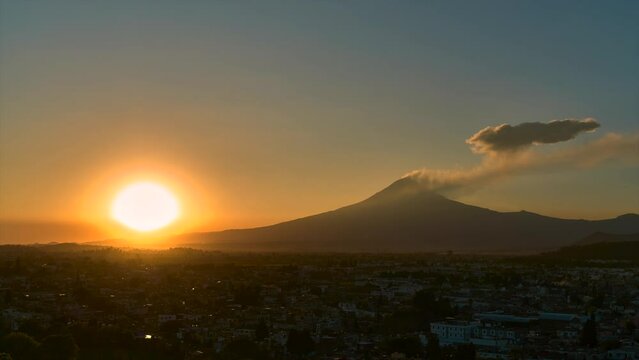 Sunset over the exploding Popocat&eacute;petl volcano, from Cholula,time lapse