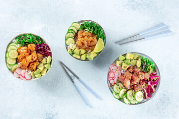 Poke bowl, healthy Hawaiian dish, variety. Plates with salmon, tuna, and shrimps, overhead flat lay...