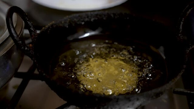 Bubbling Hot Oil With Guror Handesh Cooking Underneath In Small Pan. Slow Motion